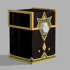 Könnte beinhalten: Eine Holzkiste mit goldener Einfassung und einem geometrischen Muster in Grün und Gold. Die Kiste hat ein transparentes Plastikfenster auf der Vorderseite, das einen weißen sechseckigen Prisma zeigt.