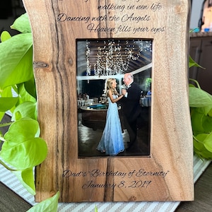 May include: A wooden picture frame with a carved inscription that reads "Dancing with the Angels walking in new life Dancing with the Angels Heaven fills your eyes Dad's "Birthday of Eternity" January 8, 2019". The frame holds a photo of a couple dancing.