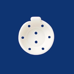 May include: A white, circular kitchen gadget with multiple small holes and a handle. The object is set against a solid blue background. The design features a central area with three holes and a ring of six surrounding holes.