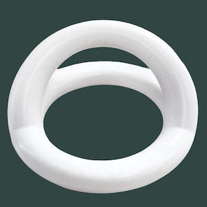 May include: A white, circular object with a smooth, glossy finish. The object is composed of two interlocking rings, creating a figure-eight shape. The background is a solid, dark green color.