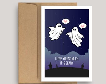 May include: A greeting card with a dark blue night sky background featuring two white ghosts, each with a pink heart speech bubble. The text reads I LOVE YOU SO MUCH IT'S SCARY above a black silhouette of a landscape with two small buildings.