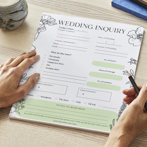 May include: A white wedding inquiry checklist with black floral illustrations. The checklist includes sections for contact information, date of wedding, location of wedding, what the couple wants, photo budget, video budget, and notes to remember.