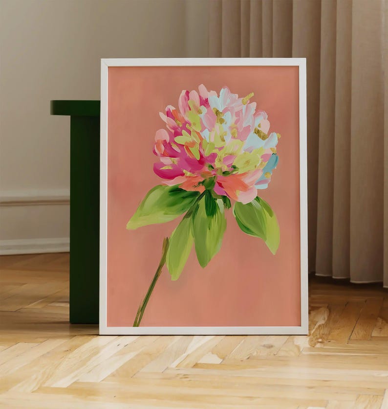 May include: A framed painting of a pink, white, and green flower with a peach background.