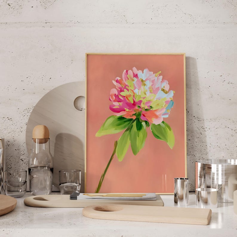 May include: A framed painting of a pink, white, and green flower with a peach background.