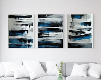 May include: Three abstract paintings in black, white, and blue. The paintings are in a horizontal format and feature thick brushstrokes. The paintings are framed in white.