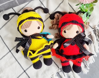 May include: Two crocheted stuffed toys, one a bee with yellow and black stripes and the other a ladybug with red and black spots. Both toys have black eyes and are sitting on a white and gray checkered surface.