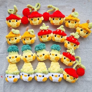 Peut inclure: Une collection d'ornements de poussins crochetés à la main sur le thème des fruits. Les poussins sont jaunes avec des ventres blancs et des yeux noirs. Ils sont coiffés de chapeaux en forme de fruits, notamment des cerises rouges, des fraises et autres fruits.