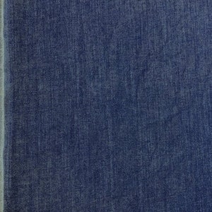 May include: Close-up of a dark blue denim fabric with a woven texture.