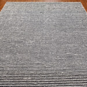 May include: Black and white patterned rug with a subtle gradient effect. The rug has a textured, woven appearance.