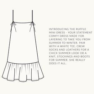 K&ouml;nnte beinhalten: Ein wei&szlig;es, &auml;rmelloses Minikleid mit einem R&uuml;schen-Saum. Das Kleid hat d&uuml;nne Tr&auml;ger, die an den Schultern gebunden werden. Der Text "INTRODUCING THE RUFFLE MINI DRESS - YOUR STATEMENT COMFY DRESS MADE FOR LAYERING TO TAKE YOU FROM SUMMER TO WINTER. PAIR WITH A WHITE TEE, CREW SOCKS AND LOATHERS FOR A CHICK SUMMER LOOK OR A KNIT, STOCKINGS AND BOOTS FOR SUMMER. SHE REALLY DOES IT ALL." steht unter dem Kleid.