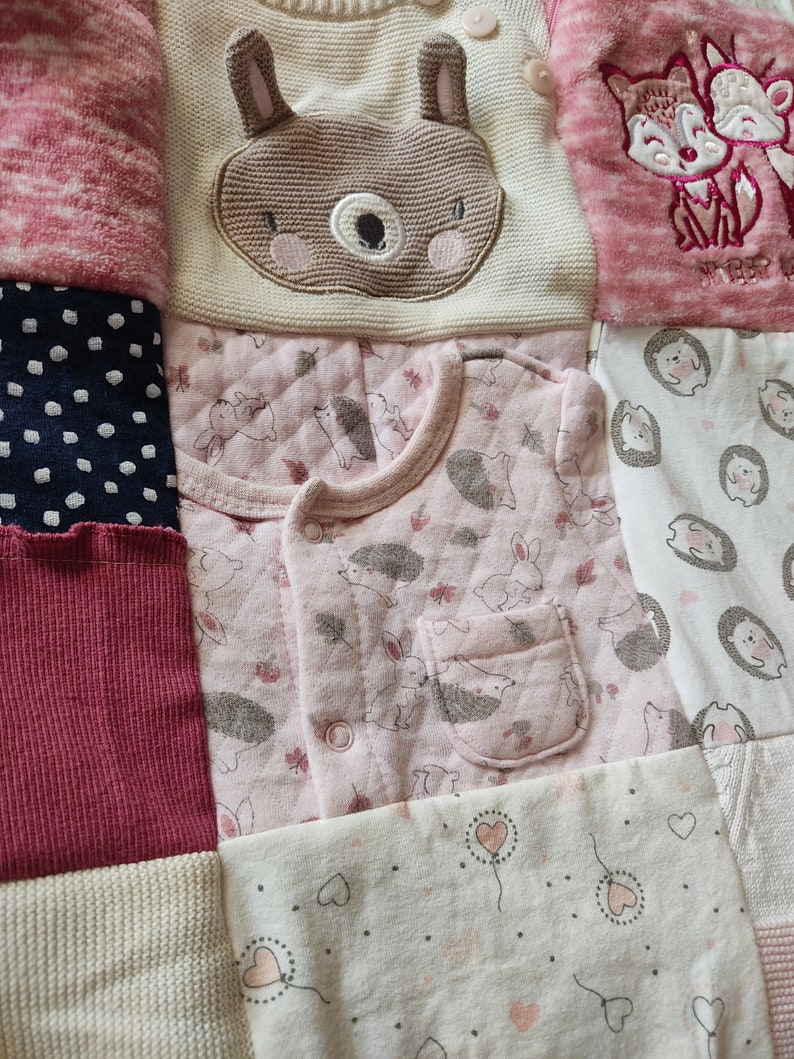 Puede incluir: Un mosaico de ropa de beb&eacute; en tonos rosa, blanco y azul marino. Los art&iacute;culos incluyen un su&eacute;ter color crema con una cara de oso, un body rosa con erizos y conejos y un su&eacute;ter rosa con un dise&ntilde;o de zorro.