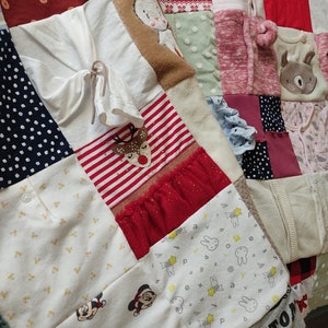 Puede incluir: Un edred&oacute;n de patchwork compuesto por varios retazos de tela, incluyendo blanco, rojo y azul marino. El edred&oacute;n presenta patrones como lunares, rayas y personajes de dibujos animados. Algunas secciones tienen elementos decorativos como volantes y dise&ntilde;os bordados.