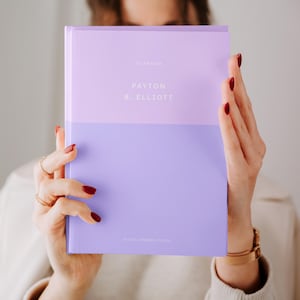 Könnte beinhalten: Ein lilafarbener Planer mit dem Text "PLANNER" und "PAYTON B. ELLIOTT" in Weiß.