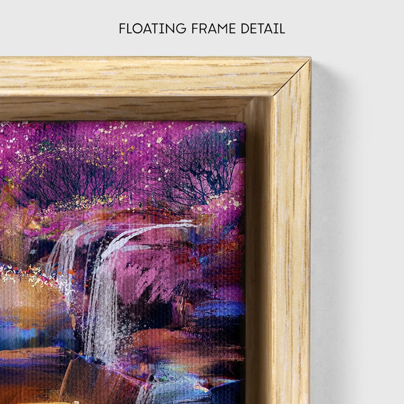 May include: A framed painting of a waterfall in a forest with pink and purple trees. The frame is a light wood colour and has a floating effect.