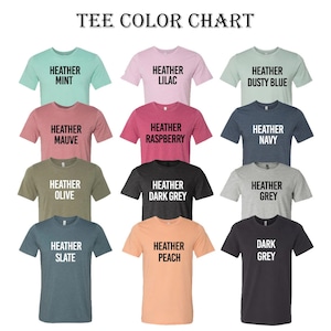May include: Color chart showing 12 different heather and dark grey t-shirt colors. The colors are: Heather Mint, Heather Lilac, Heather Dusty Blue, Heather Mauve, Heather Raspberry, Heather Navy, Heather Olive, Heather Dark Grey, Heather Grey, Heather Slate, Heather Peach, Dark Grey.