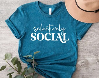May include: A teal blue t-shirt with the text "selectively SOCIAL" in white lettering.
