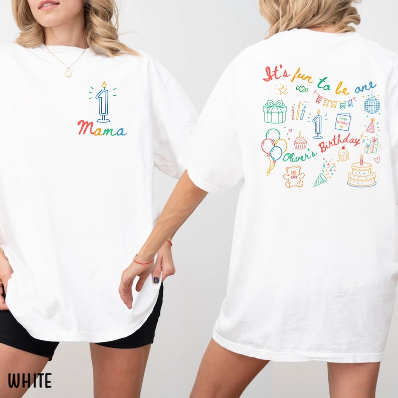 May include: White t-shirts with colorful birthday-themed graphics. One shirt features a candle with the number 1 and the word "Mama". The other shirt has the phrase "It's fun to be one" with birthday icons and the name "Oliver's Birthday".