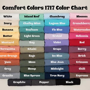 May include: A color chart titled "Comfort Colors 1717 Color Chart" displays a variety of fabric colors. Colors include white, ivory, banana, butter, mustard, terracotta, burnt orange, yam, grey, granite, island reef, chalky mint, seafoam, light green, bay, khaki, sage, moss, hemp, blue spruce, graphite, pepper, black, chambray, lagoon blue, flo blue, orchid, violet, grape, ice blue, blue jean, midnight, true navy, blossom, crunchberry, watermelon, heliconia, red, berry, brick, crimson, chili, and espresso.