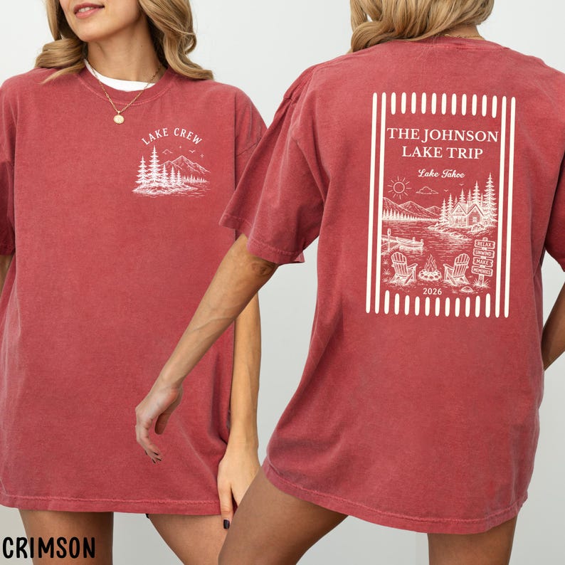 Puede incluir: Camisetas color carmes&iacute; con dise&ntilde;os gr&aacute;ficos blancos. Una camiseta presenta "LAKE CREW" con una escena de monta&ntilde;a y &aacute;rboles. La otra muestra "THE JOHNSON LAKE TRIP Lake Tahoe 2026" con una escena de lago, sillas y una fogata.
