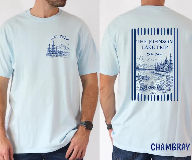 Puede incluir: Camiseta azul claro con un gr&aacute;fico de la orilla del lago en la parte delantera y trasera. La parte delantera presenta un dise&ntilde;o de monta&ntilde;a y &aacute;rboles con el texto "LAKE CREW". La parte trasera muestra una escena del lago con el texto "THE JOHNSON LAKE TRIP Lake Tahoe 2026".