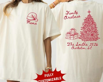 May include: An ivory t-shirt featuring a red graphic of a Santa hat and the word Mama on the front. The back displays a red Christmas tree, gift boxes, and the text Family Christmas, The Smiths 2026, and Charleston, SC in red ink.