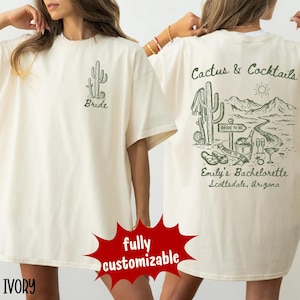 May include: Ivory-colored t-shirt with a cactus graphic and the word "Bride" on the front. The back features a desert scene with cacti, mountains, and the text "Cactus & Cocktails," "Bride to Be," and "Emily's Bachelorette Scottsdale, Arizona."