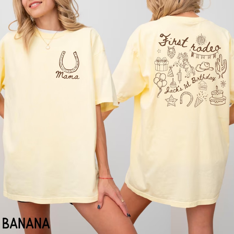 K&ouml;nnte beinhalten: Hellgelbes T-Shirt mit einem Hufeisen und dem Wort "Mama" auf der Vorderseite. Auf der R&uuml;ckseite des Shirts steht der Text "First rodeo" und verschiedene Illustrationen zum Thema Rodeo, darunter ein Pferd, ein Kaktus und eine Geburtstagstorte.