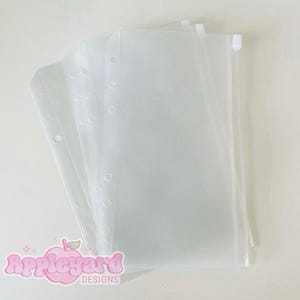 May include: A set of translucent, frosted plastic zip pouches designed for a binder. Each rectangular pouch features a vertical row of six punched holes along the left edge for ring binding and a white plastic zip closure at the top.