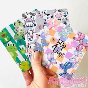 May include: Three square cards featuring colourful illustrations. One card has green frogs on white and green stripes. Another shows black and white cows on a grey background. The third card displays balloon dogs on a checkered background with text 50p Dogs.