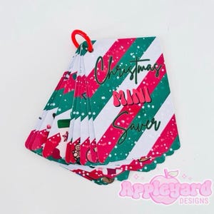 May include: A set of rectangular cards held together by a red plastic ring. The cards feature a diagonal striped pattern in red, white, and green with white speckles. The top card displays the text Christmas MINI Saver in a dark green font.
