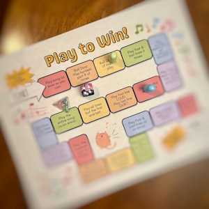 Könnte beinhalten: Ein farbenfrohes Spielbrett mit dem Aufdruck "Play to Win!" Das Brett hat verschiedene farbige Felder mit Anweisungen zum Spielen eines Spiels. Die Anweisungen beinhalten das Spielen eines Liedes so langsam wie möglich, das Spielen des schwierigsten Teils eines Liedes eine bestimmte Anzahl von Malen, das Spielen des gesamten Liedes als Emoji, das Spielen aller Zeilen außer der ersten und letzten, das Spielen der ersten Zeile laut und der letzten Zeile leise sowie das Spielen der ersten und letzten Zeile fünf Mal.
