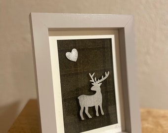 Moonlit Deer Collage. Silver painted wooden Deer and Heart shaped Moon on Dark Green Tartan Fabric Background