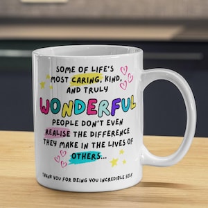 Puede incluir: Taza de café de cerámica blanca con una cita colorida que dice: "Algunas de las personas más cariñosas, amables y verdaderamente maravillosas de la vida ni siquiera se dan cuenta de la diferencia que hacen en la vida de los demás... Gracias por ser tú mismo, increíble tú."