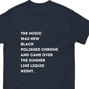 Peut inclure: T-shirt bleu marine avec un texte blanc qui dit "THE MUSIC WAS NEW BLACK POLISHED CHROME AND CAME OVER THE SUMMER LIKE LIQUID NIGHT."