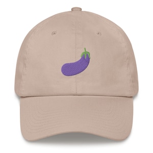 May include: A beige baseball cap with an embroidered eggplant design. The eggplant is purple with a green stem.