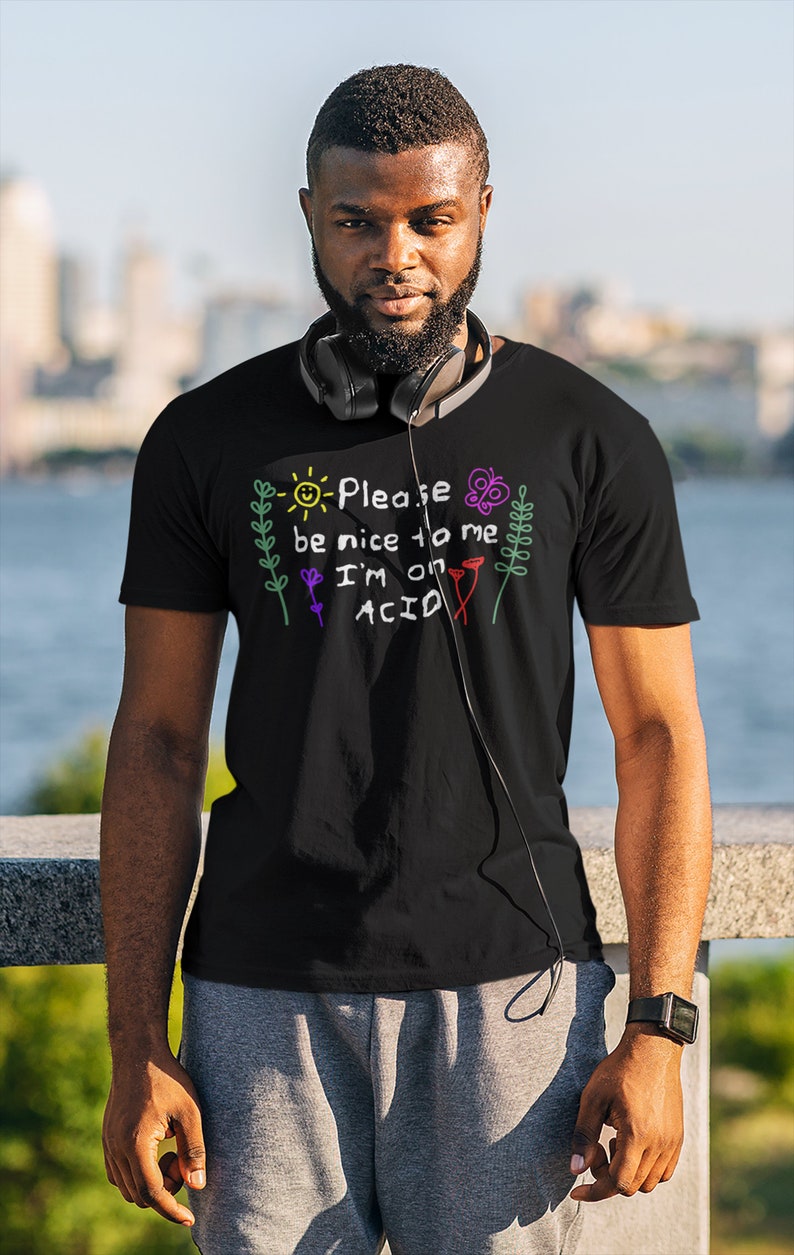 May include: A black t-shirt with a colorful graphic that says "Please be nice to me I'm on ACID". The graphic is drawn in a childlike style with a sun, flowers, and butterflies.