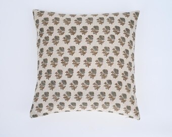 May include: A cream-colored pillow with a floral pattern in shades of brown and green. The pillow is made of a soft, textured fabric.