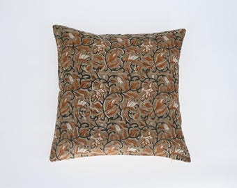 May include: A brown and beige throw pillow with a floral pattern. The pillow has a square shape and is made of a soft fabric.