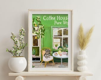 May include: A framed illustration of a green building with a sign that reads "Coffee House Pure Veg." A small dog sits on a chair outside the building. There are plants and a table with pastries and drinks.