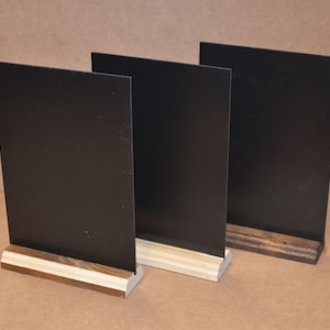 May include: Three black chalkboard signs with wooden bases. The signs are blank and ready to be written on.