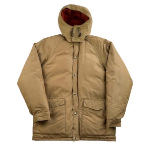 May include: A brown hooded jacket with a red lining and a button closure. The jacket has two large pockets on the front and a drawstring hood.