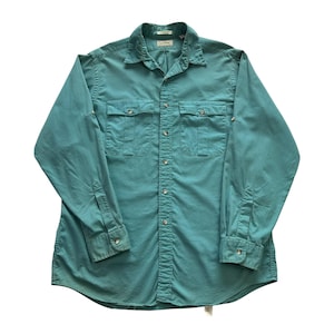 Op de afbeelding: Een tealkleurig button-down overhemd met twee borstzakken en manchetten met knopen. Het shirt met lange mouwen heeft een kraag en een klassieke, casual stijl. Het shirt is gemaakt van een duurzame stof.