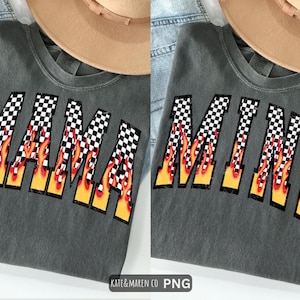 May include: Two gray t-shirts with the words "MAMA" and "MINI" in a checkered pattern with flames. A tan hat rests on top of each shirt. The shirts are on a denim background.