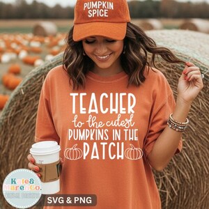 May include: An orange baseball cap with the text PUMPKIN SPICE and an orange t-shirt featuring the white text TEACHER to the cutest PUMPKINS IN THE PATCH with two pumpkin illustrations. The shirt is held with a hand holding a white coffee cup.