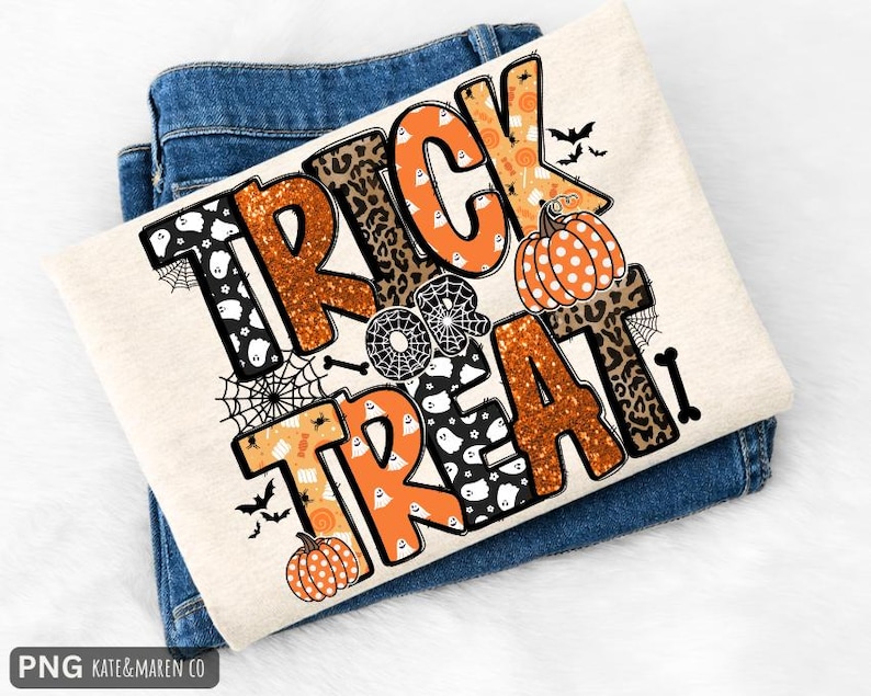 Puede incluir: Una camiseta de color crema con el texto TRICK OR TREAT en letras grandes y estilizadas. El dise&ntilde;o incorpora purpurina naranja, estampado de leopardo y patrones negros con fantasmas blancos, calabazas, telara&ntilde;as, murci&eacute;lagos y huesos.