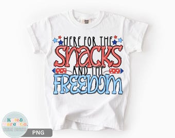 May include: White t-shirt with the text "HERE FOR THE SNACKS AND THE FREEDOM" in red and blue. The design includes stars and firework graphics, perfect for patriotic celebrations.