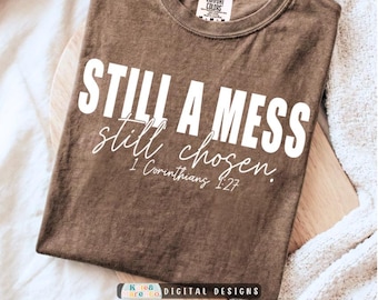 Może przedstawiać: Brązowy t-shirt z krótkim rękawem z białym napisem STILL A MESS still chosen. 1 Corinthians 1:27. Koszulka posiada okrągły dekolt oraz metkę przy wewnętrznej stronie kołnierza. Materiał ma lekko wyblakły, teksturowany wygląd.