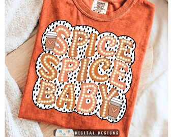 May include: A burnt orange t-shirt featuring a graphic with the text SPICE SPICE BABY in large, light-colored, dotted letters. The design includes two coffee cup illustrations with heart icons, all set against a black and white polka dot background.