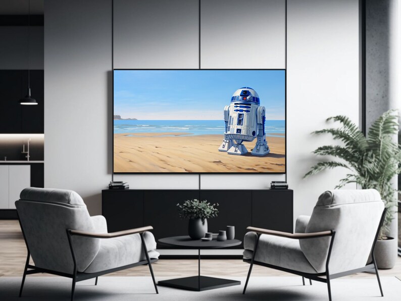 May include: A white and blue robot stands on a sandy beach with a blue ocean and sky in the background. The robot is facing away from the viewer and has a round head with a single eye.