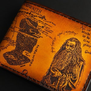 May include: A brown leather wallet with a map of Middle-earth and a portrait of Gandalf. The quote "All we have to decide is what to do with the time that is given us" is printed on the wallet.